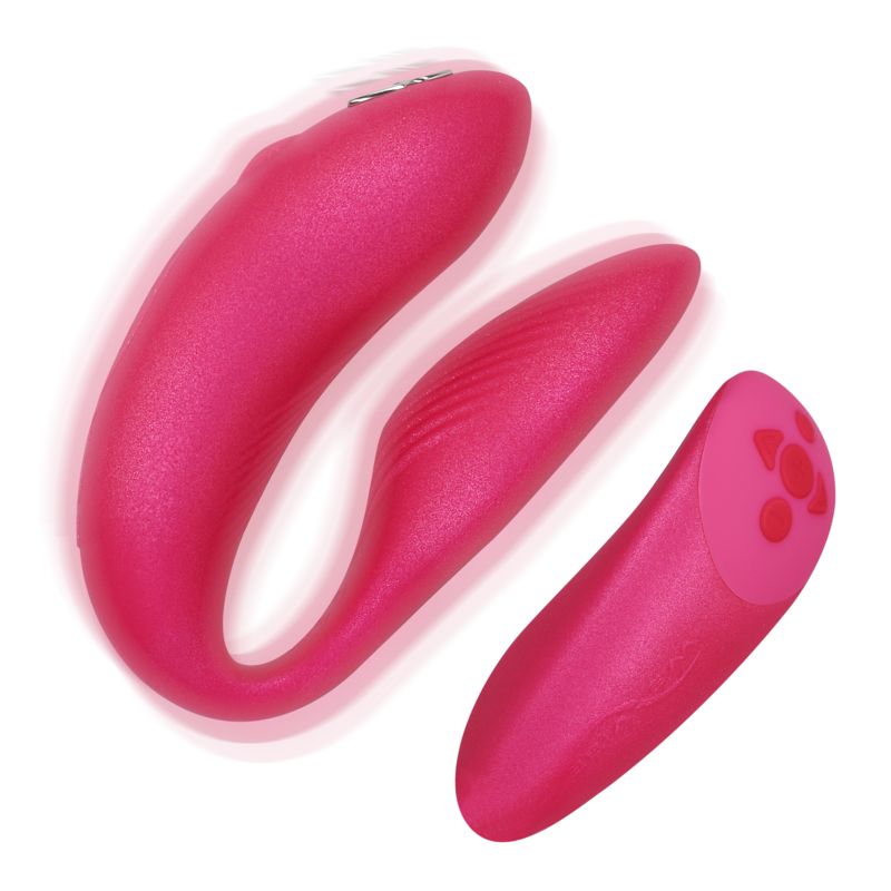 Pinkfarbener Vibrator für Paare. U-förmiger Hauptteil mit einem separaten, länglichen Element. Oberfläche mit Rillen und Knöpfen.