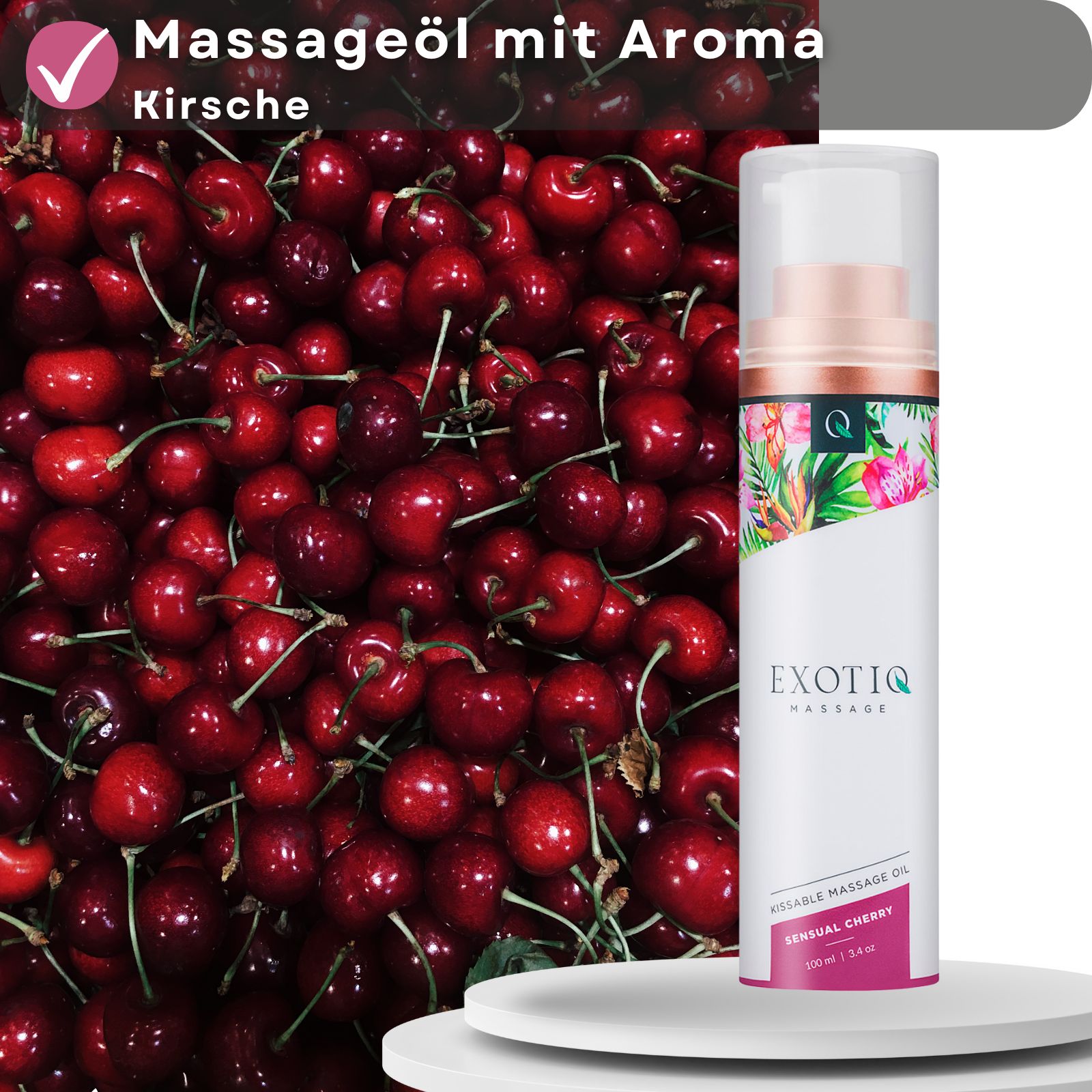 Massageöl-Flasche vor Kirschen. Aufschrift: Massageöl mit Aroma Kirsche. Produktname und Logo sichtbar.