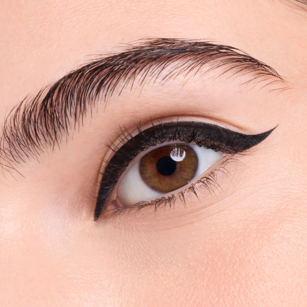 Nahaufnahme eines Auges mit schwarzem Eyeliner. Der Eyeliner ist als Flügel geformt.