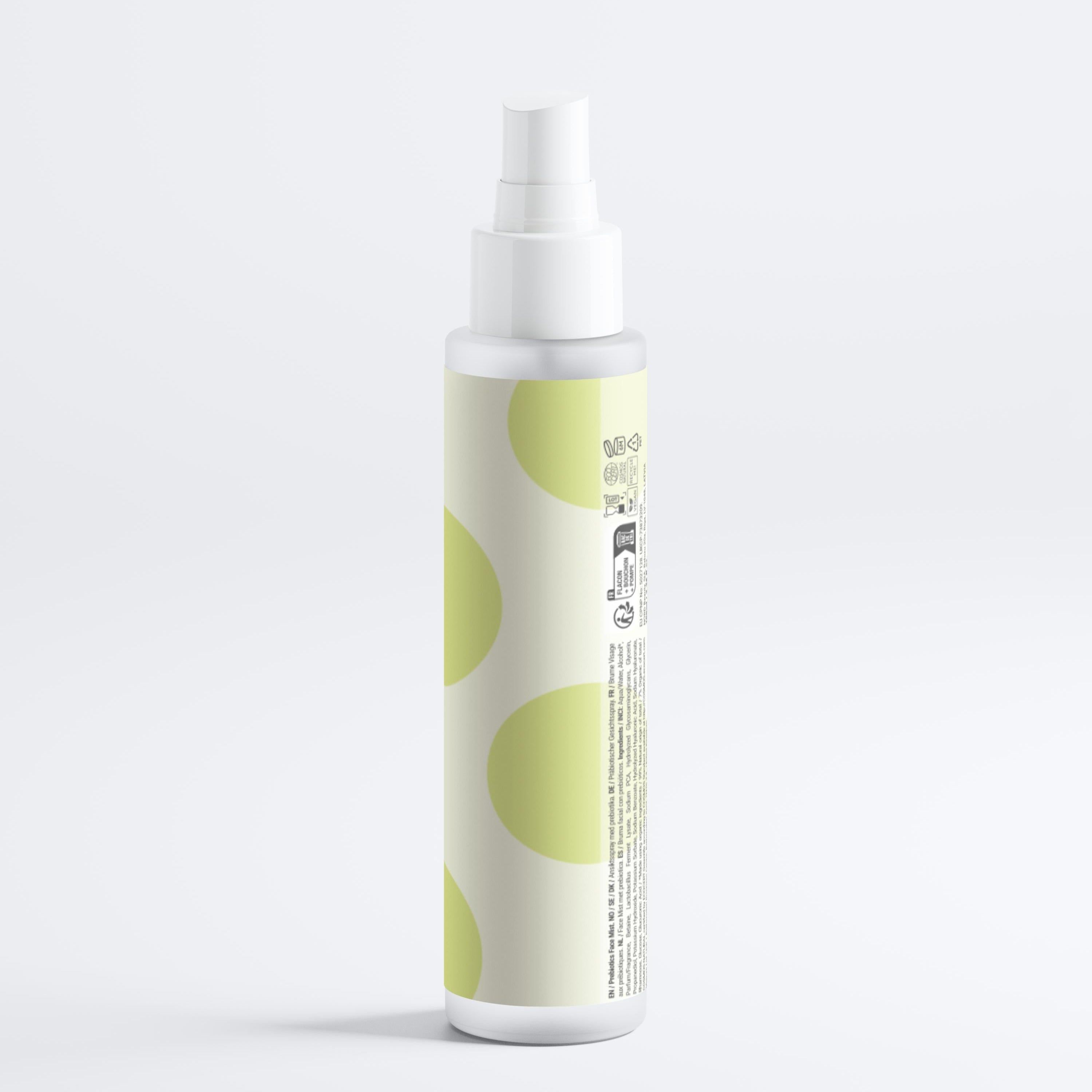Gesichtsspray-Flasche, weiß mit grünem Etikett. Gelbe Punkte auf dem Etikett. Sprühkopf oben.