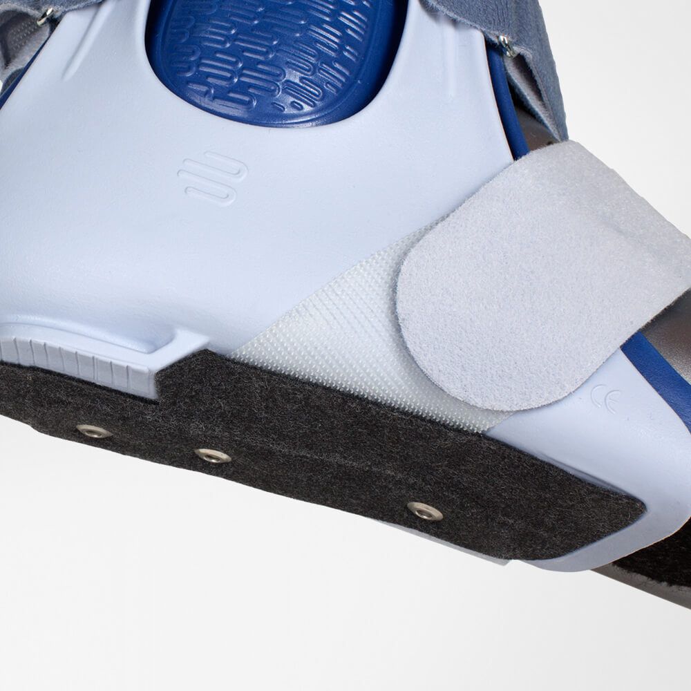 Knöchelorthese, weiß-blau, mit Klettverschluss und gepolstertem Innenfutter. Schwarze Sohlenplatte mit Nieten.