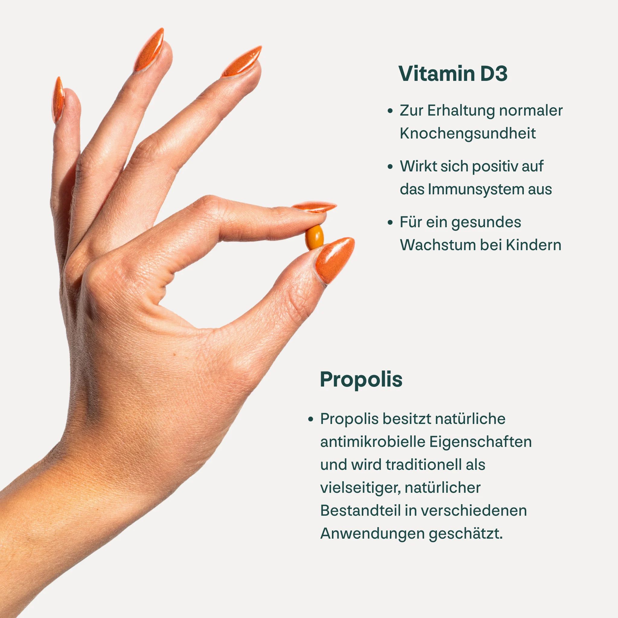 Hand hält eine Kapsel. Text: Vitamin D3, Propolis. Vitamin D3 für Knochengesundheit, Immunsystem, Wachstum. Propolis: antimikrobiell.