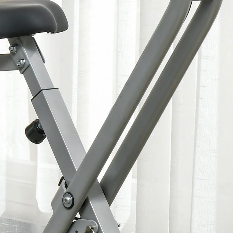 Graue Metallstreben eines Heimtrainers. Im Hintergrund ein weißer Vorhang.