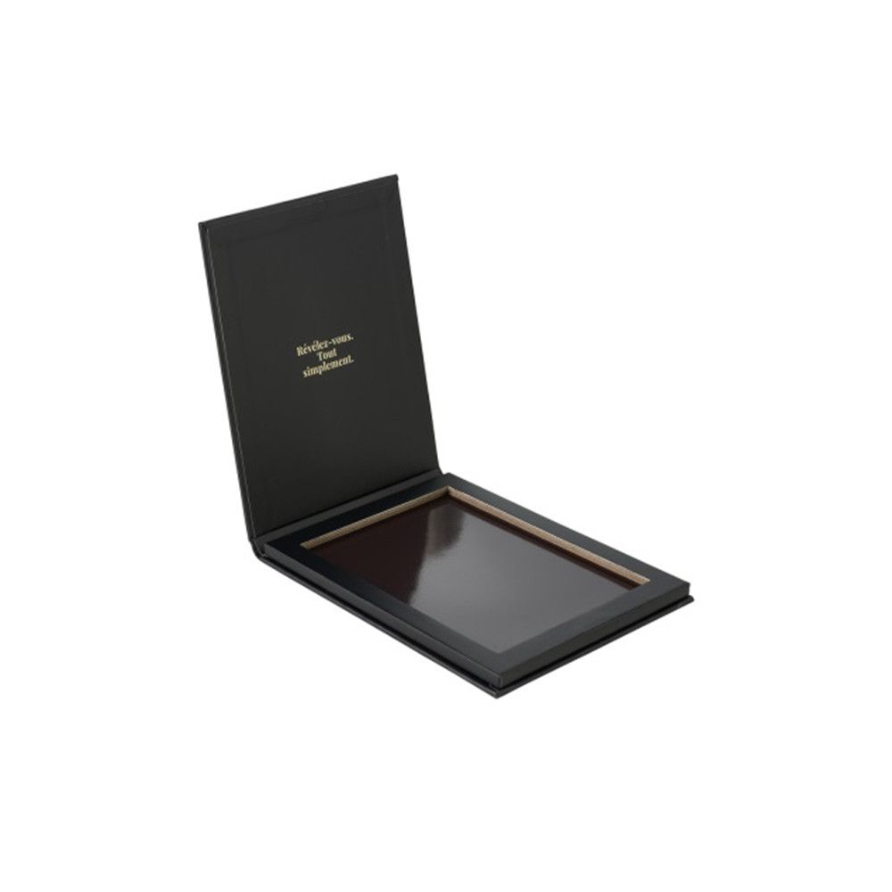 Schwarze, rechteckige Palette, geöffnet. Innenrahmen mit leerer Fläche. Deckel mit Text. Marke nicht sichtbar.