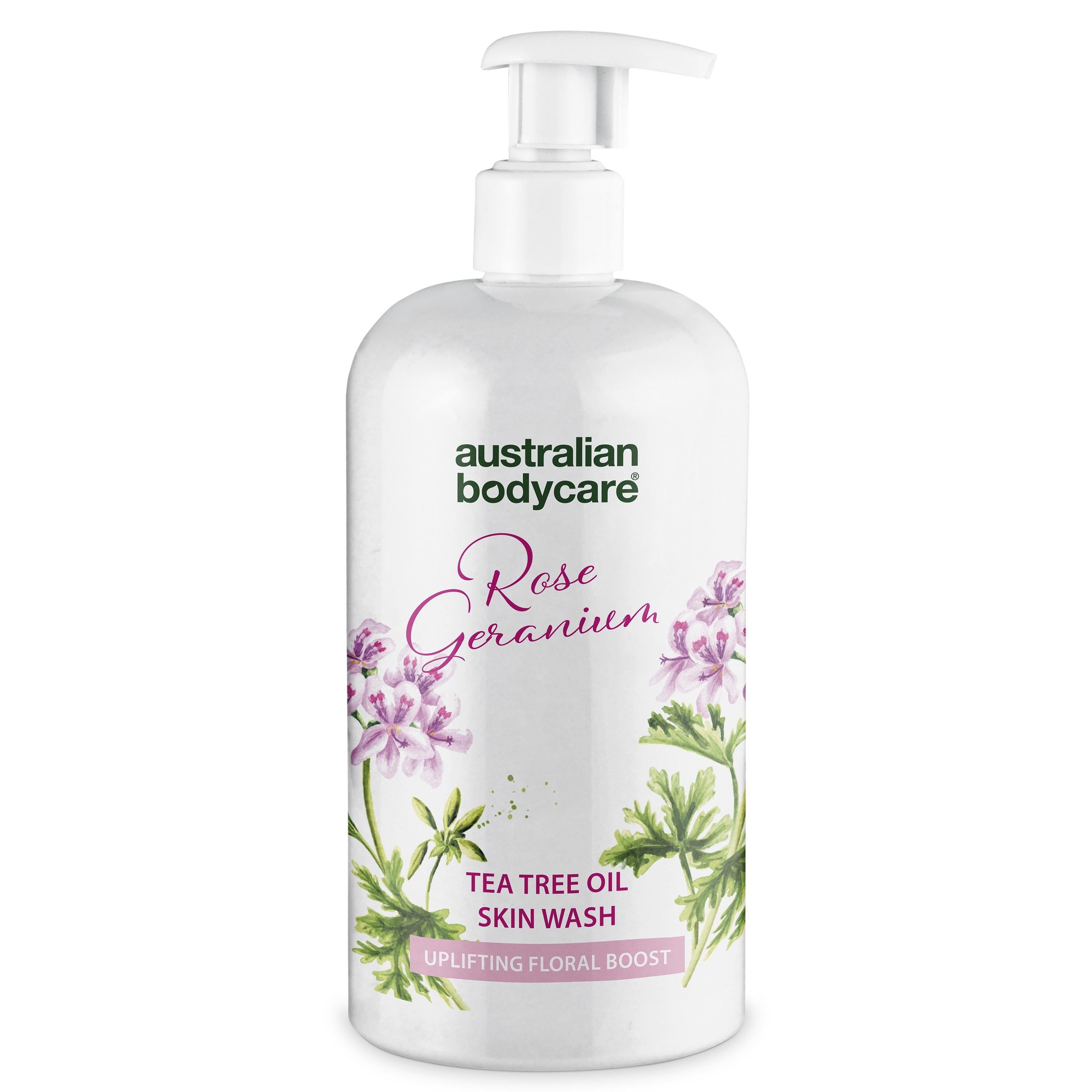 Weiße Flasche mit Pumpe. Aufschrift: Rose Geranium, Tea Tree Oil Skin Wash. Blumendekor.