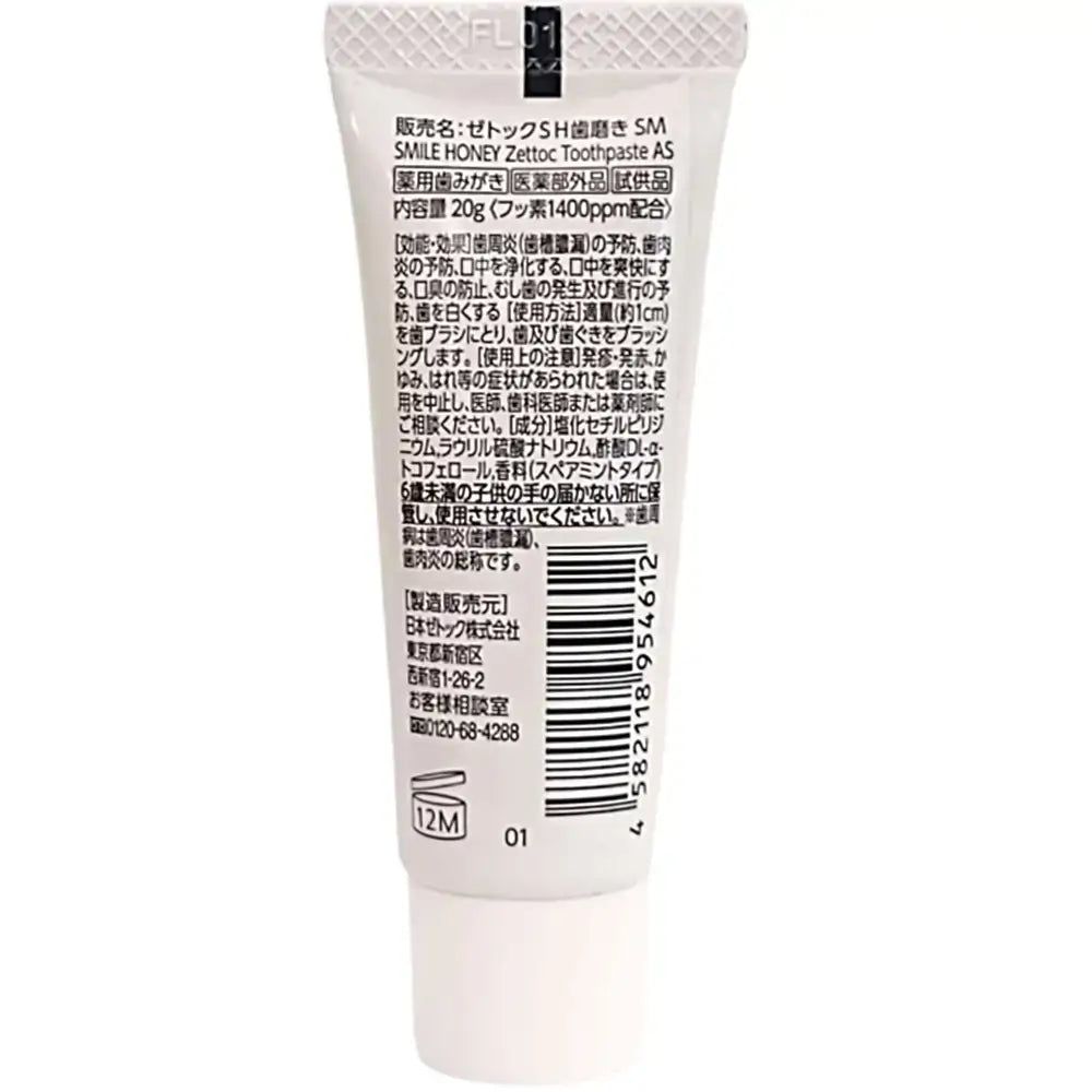 Rückseite einer Zahnpasta-Tube. Text in japanischer Schrift. Weiße Tube mit schwarzer Schrift.