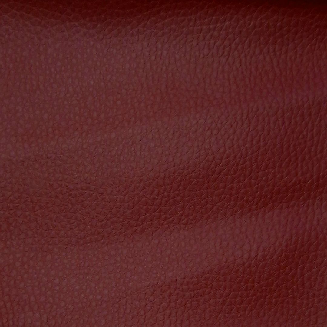 Detailansicht des roten Kunstleders. Die Oberfläche ist leicht strukturiert.
