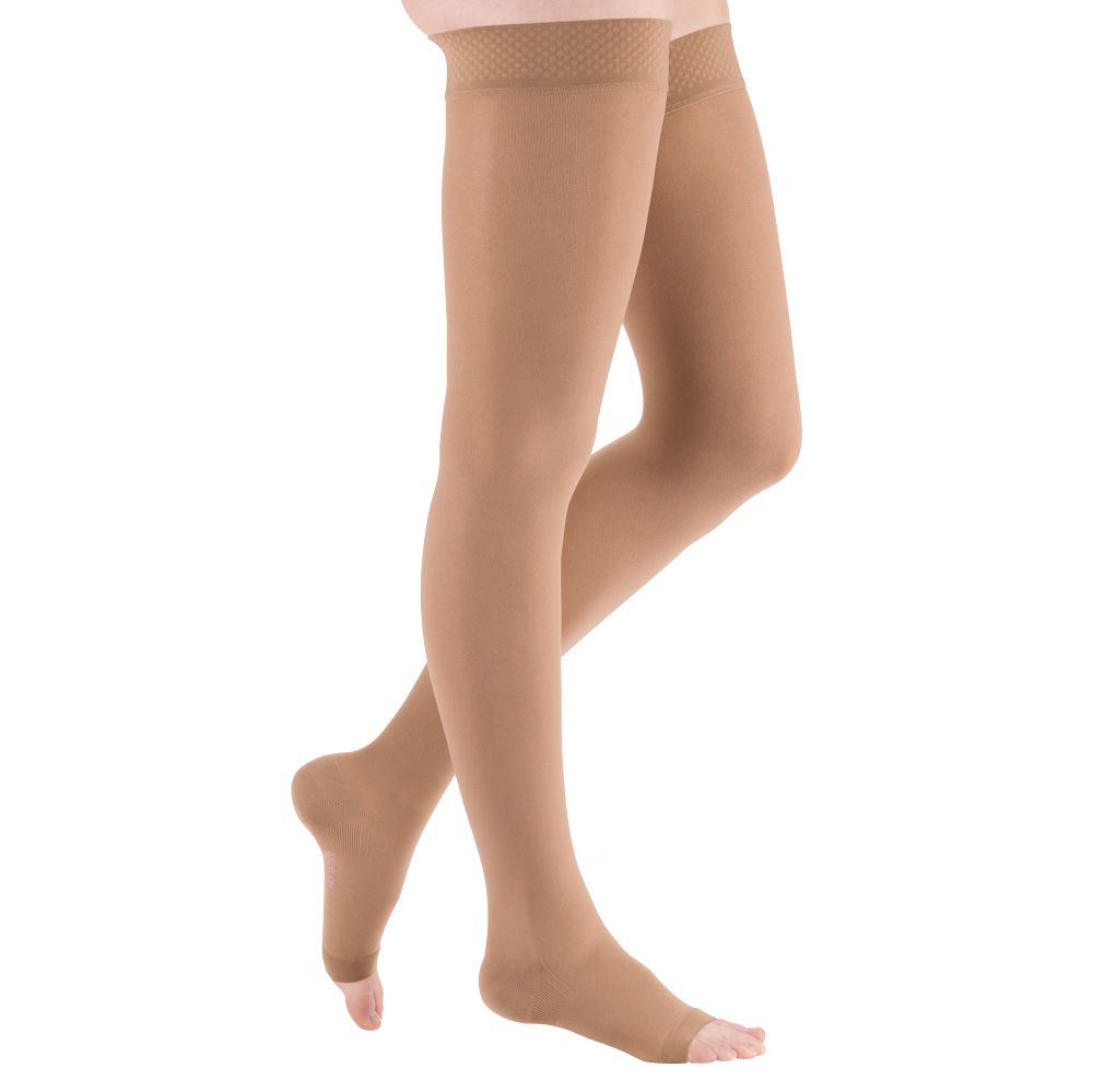 Beine mit hautfarbenen Kompressionsstrümpfen. Die Strümpfe reichen bis zum Oberschenkel und haben eine Spitze.