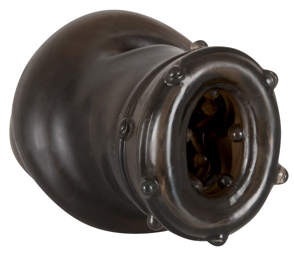 Penishülle, Seitenansicht. Schwarzes Material, Öffnung mit Noppen. Runde Form, geriffelte Oberfläche.