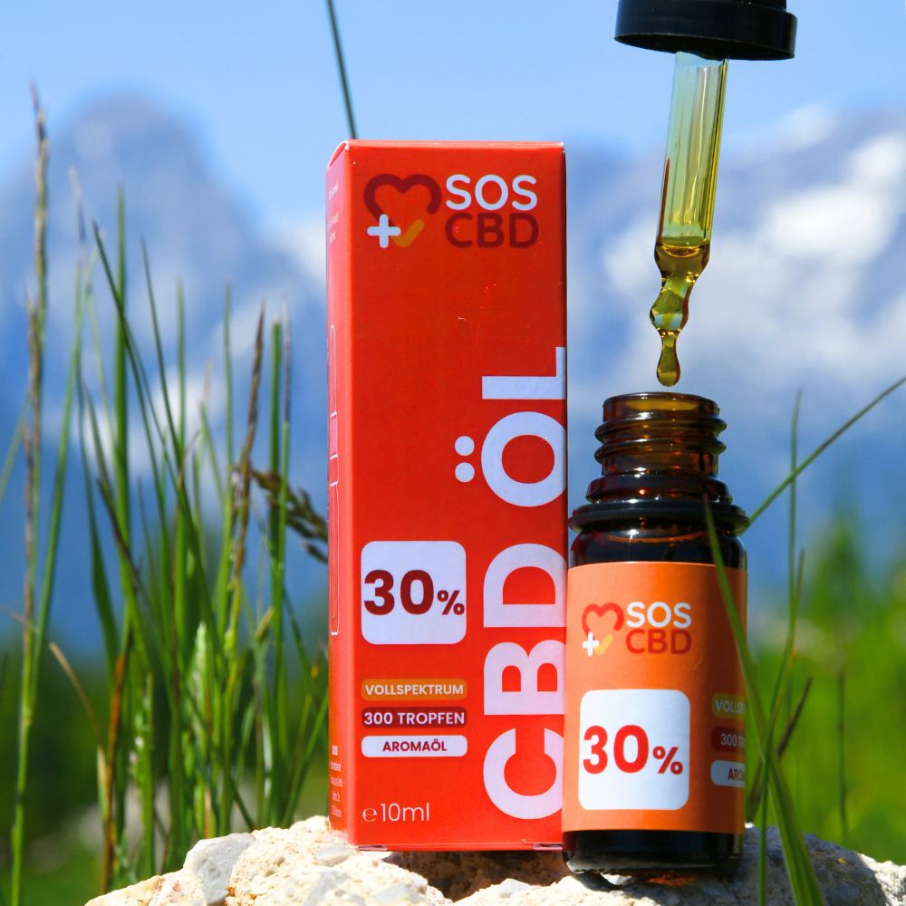 Braune Glasflasche mit schwarzem Tropfer und Tropfen. Orangefarbene Verpackung. 30% CBD, 300 Tropfen, Aromaöl. Berglandschaft im Hintergrund.