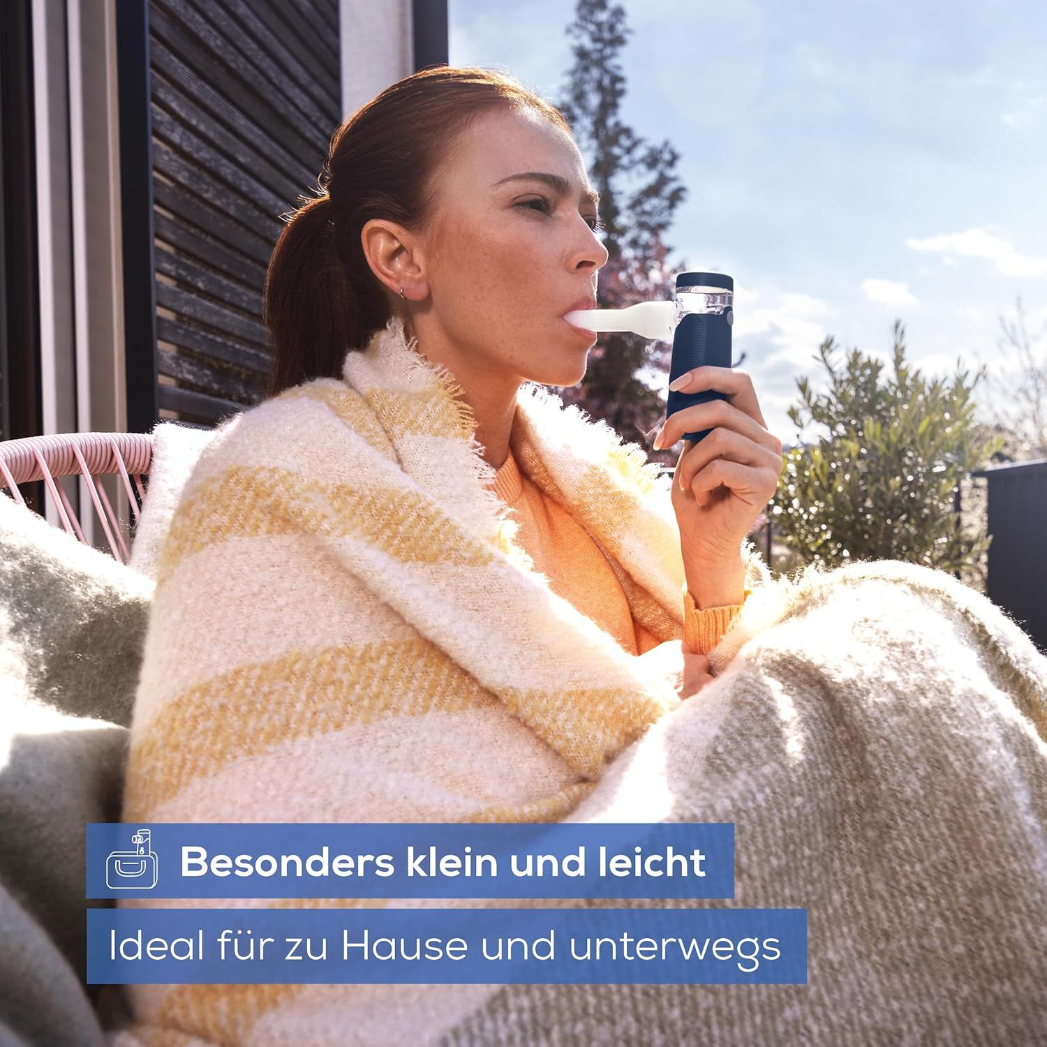 Person inhaliert mit einem blauen Inhalationsgerät. Text: Besonders klein und leicht. Ideal für zu Hause und unterwegs.