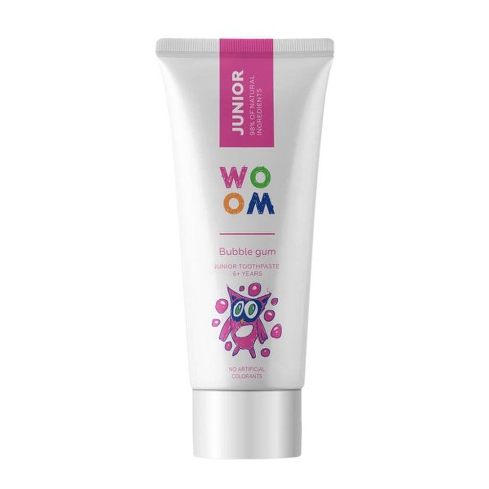 Zahncreme-Tube mit rosa Akzenten. Aufschrift "JUNIOR" und "WOOM". Abbildung eines Monsters. "Bubble gum" und "6+ years".