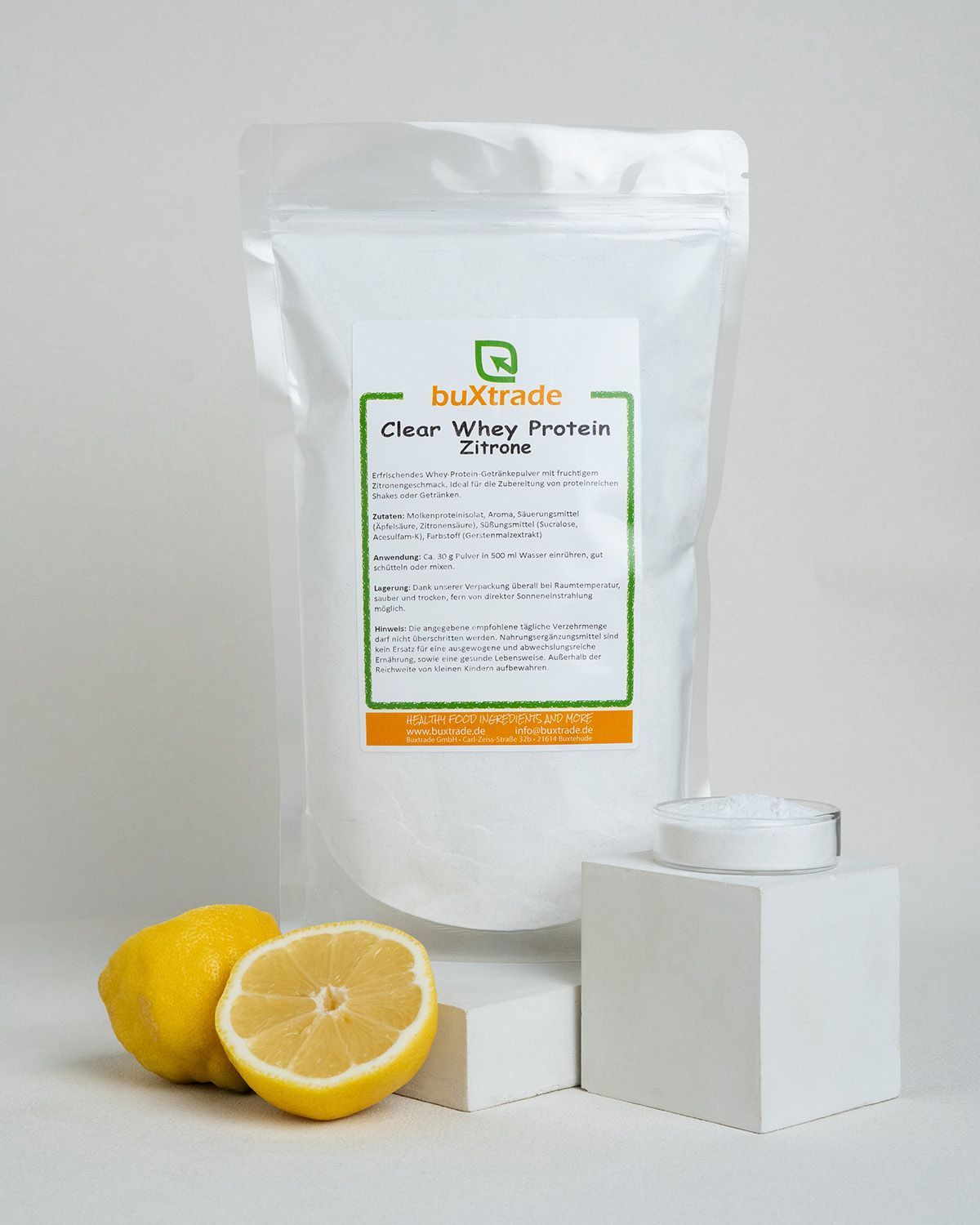 Bustrade Clear Whey Protein Zitrone in weißem Standbeutel mit Zitronen und einem kleinen Behälter mit Pulver.