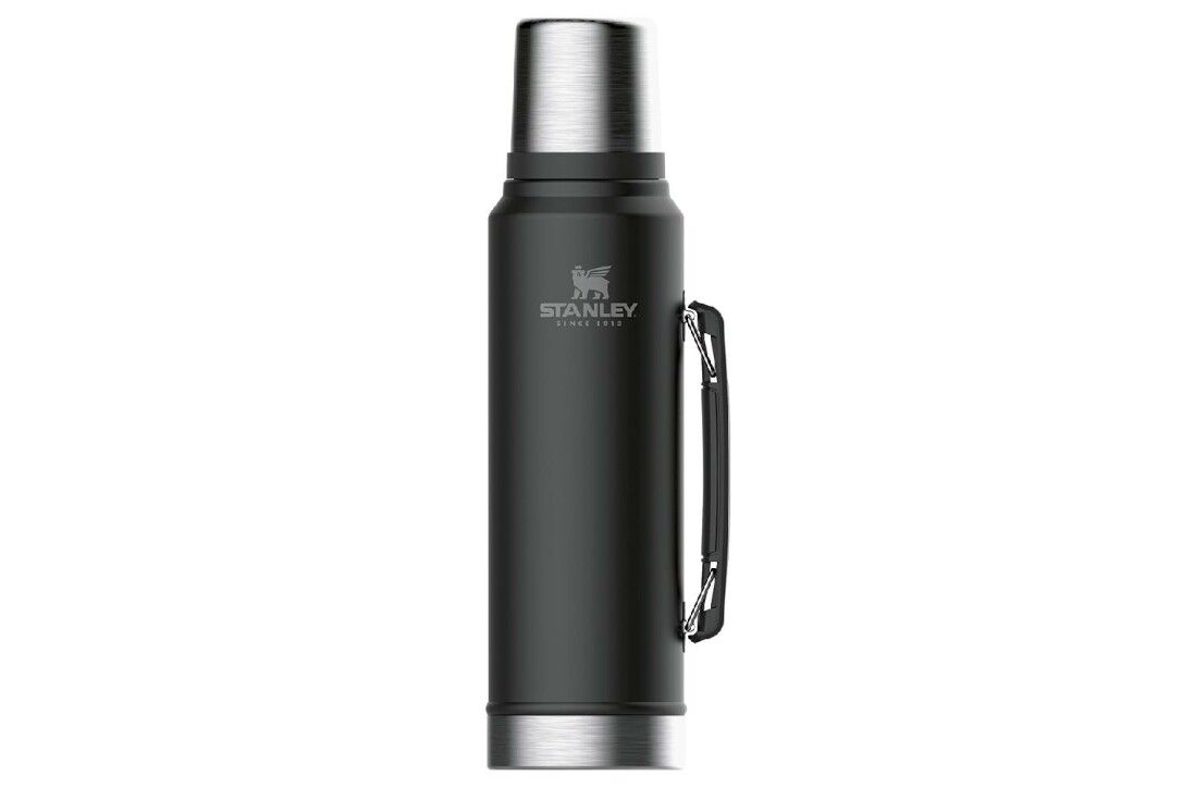 Schwarze Thermosflasche mit silbernem Deckel und Griff. Marke Stanley mit Logo. Zylindrische Form.