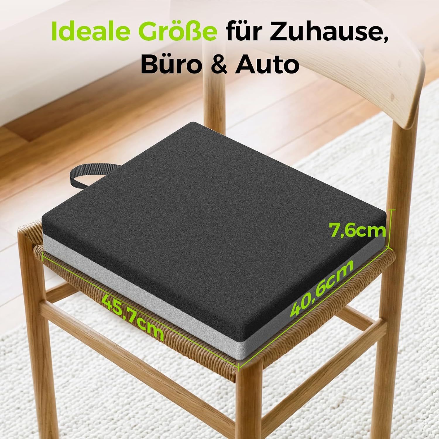 Schwarzes Sitzkissen mit Tragegriff auf einem Holzstuhl.