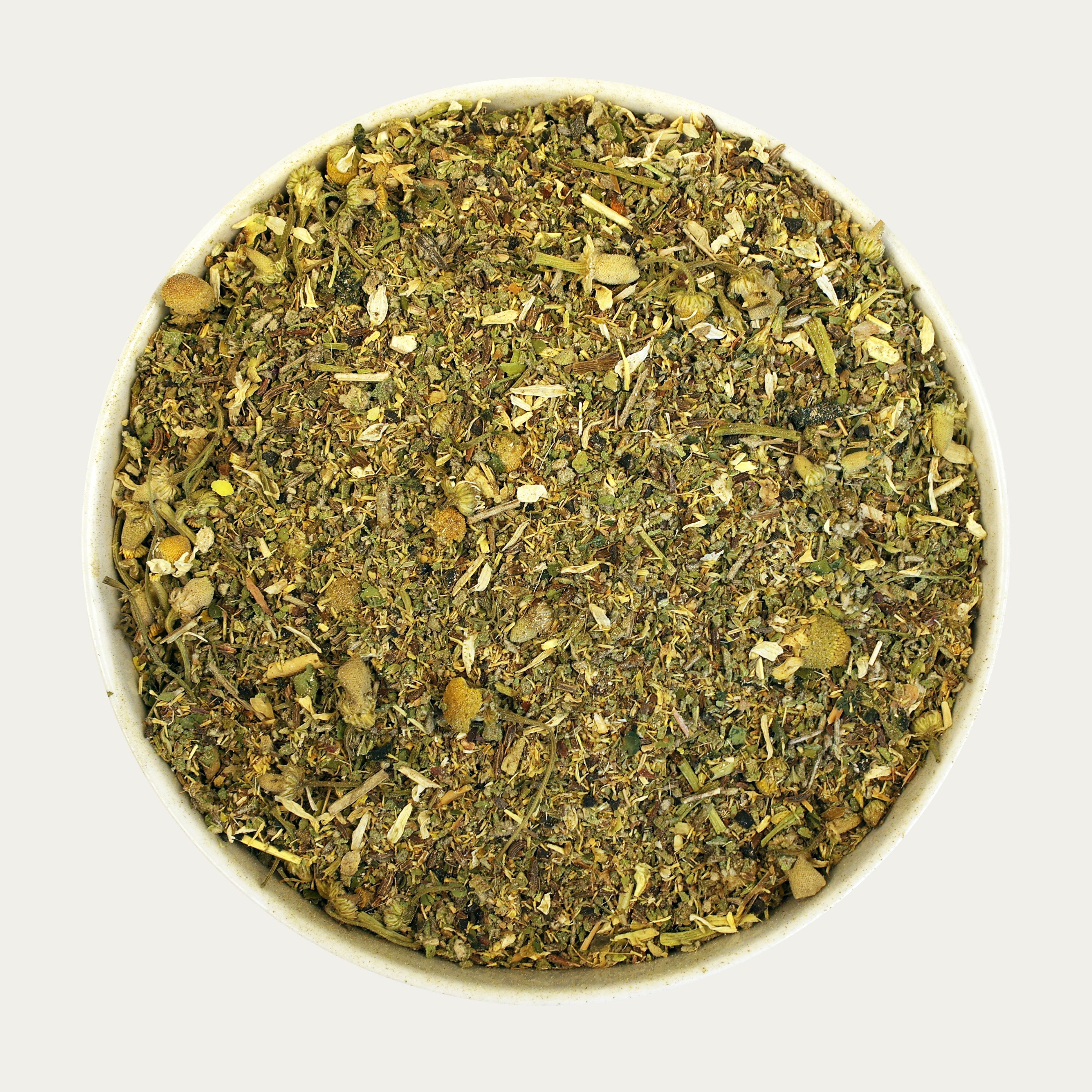 Gemisch aus Kräutern in einer weißen Schale. Die Kräuter sind in verschiedenen Grüntönen und mit gelben Blüten.