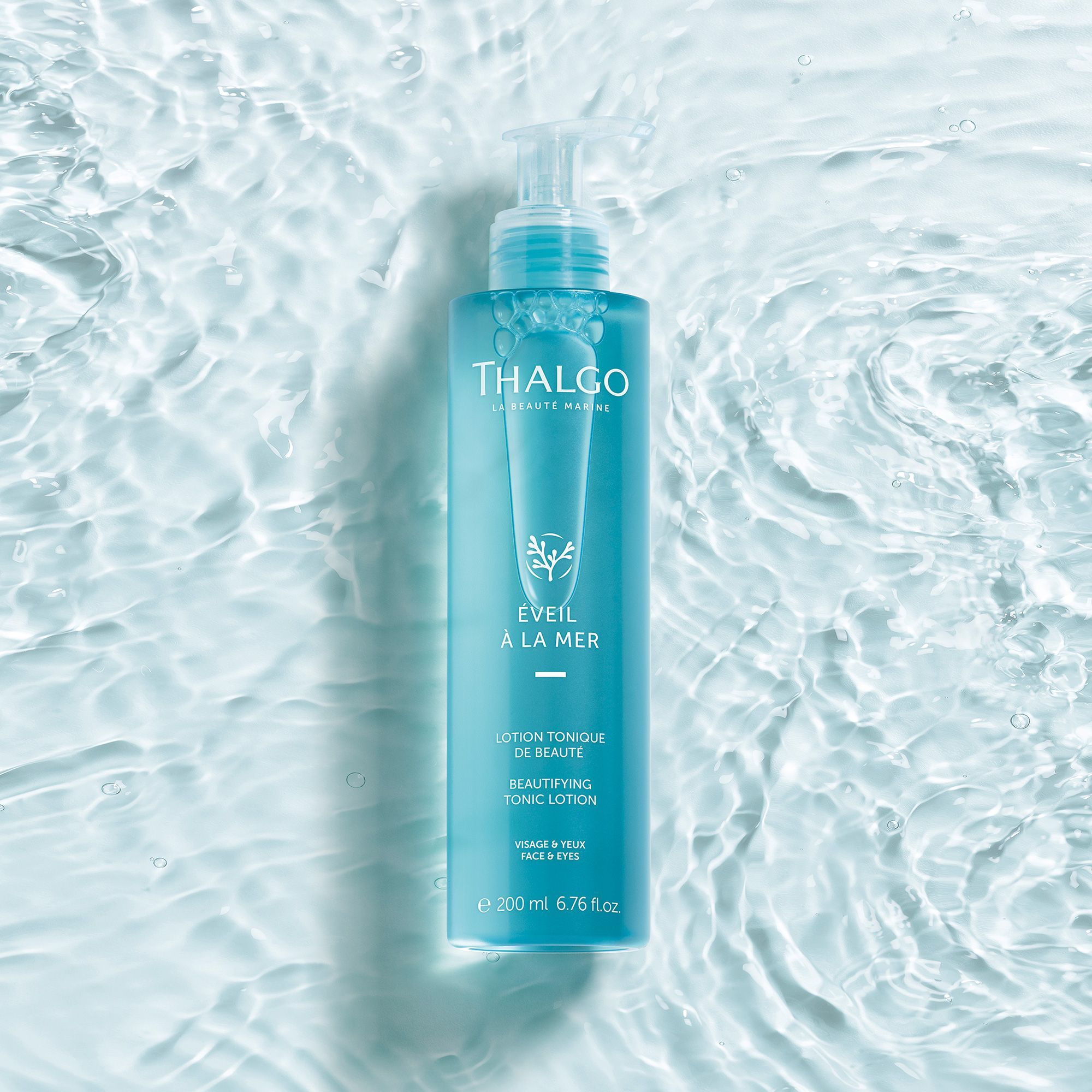 Blau-transparente Flasche mit Pumpe, im Wasser. Aufschrift: THALGO, ÉVEIL À LA MER, Lotion Tonique de Beauté, 200 ml.