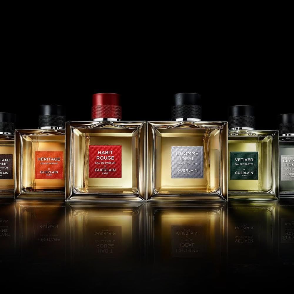 Guerlain Habit Rouge Eau de Toilette Flakon. Quadratisch, mit rotem Verschluss und Etikett. Klarer Flakon mit gelblicher Flüssigkeit.