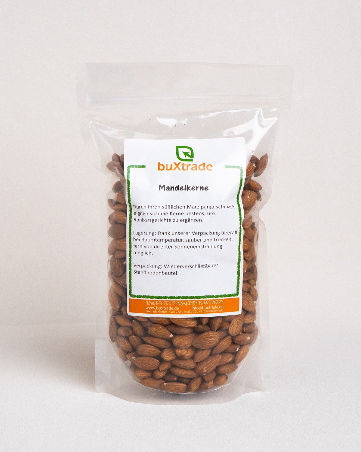 Transparente Verpackung mit Mandeln. Auf der Verpackung befindet sich ein Etikett mit Produktinformationen und dem Markennamen buXtrade.