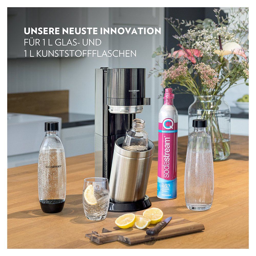 Sodastream Soda Duo Promopack mit Flaschen, Glas, Zitronen und Blumen.