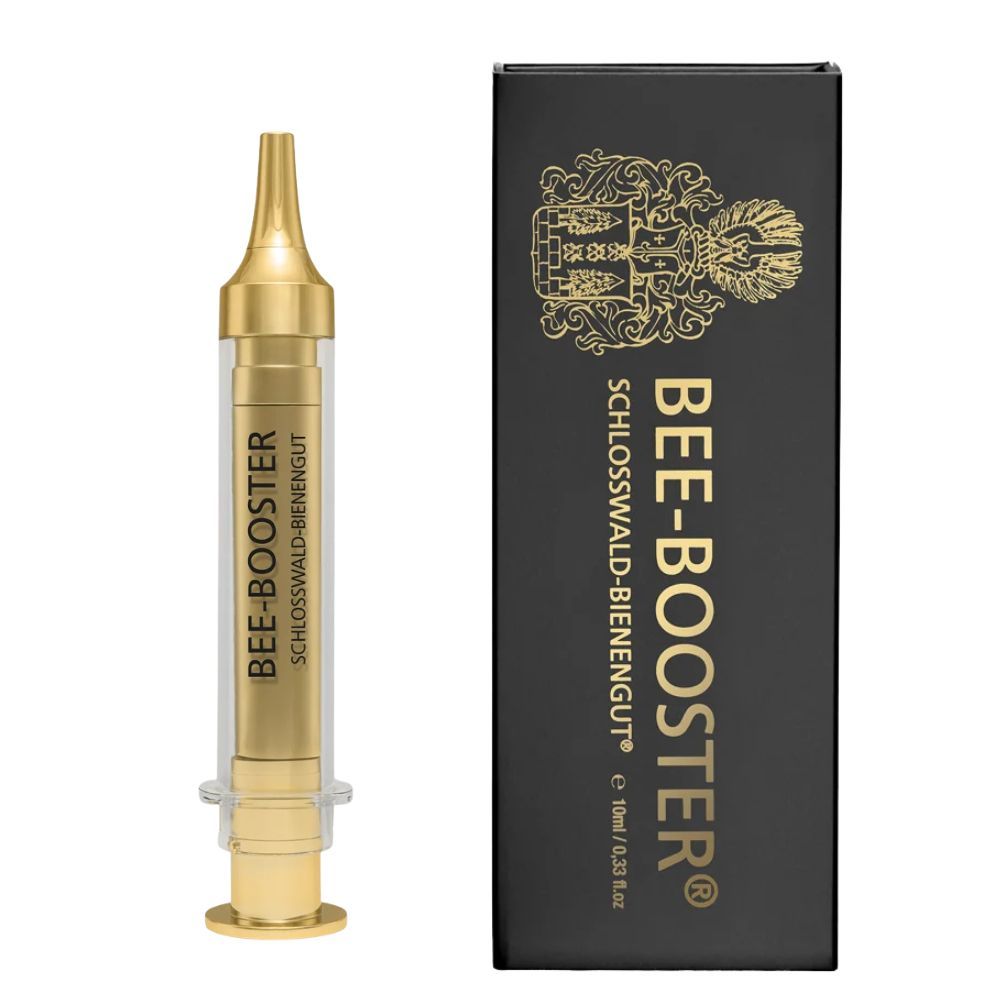 Goldfarbene Spritze und schwarze Verpackung mit goldener Schrift. Aufschrift: BEE-BOOSTER® und Schloßwald-Bienengut®.
