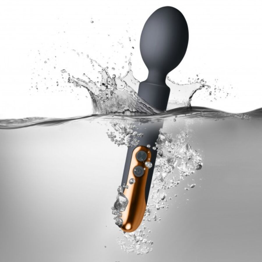 Grauer Vibrator im Wasser. Wasser spritzt. Goldfarbener Griff sichtbar.