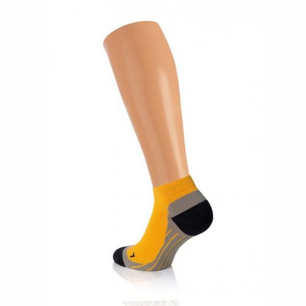 Gelbe Sportsocke mit grauem und schwarzem Akzent, auf einem Beinmodell präsentiert.