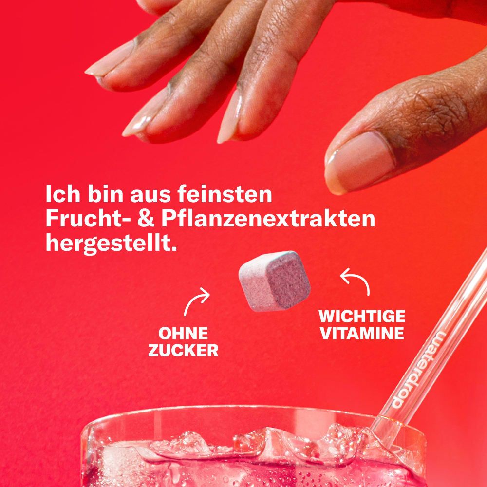 Hand hält einen waterdrop® Microenergy Cherry Boost Würfel über einem Glas.