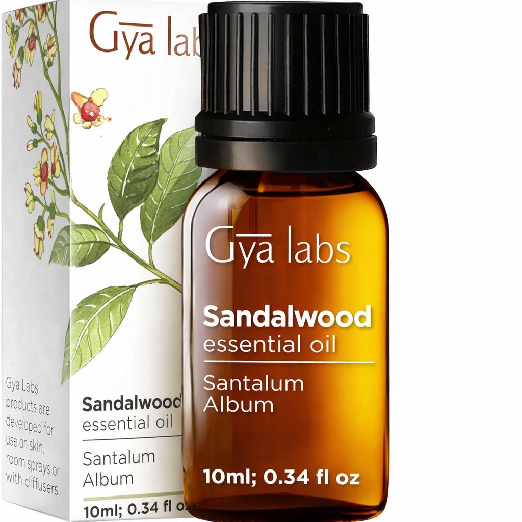 Braune Glasflasche mit schwarzem Deckel, in Schachtel. Text: "Gya Labs Sandelholz ätherisches Öl". Etikett mit Produktinformationen.