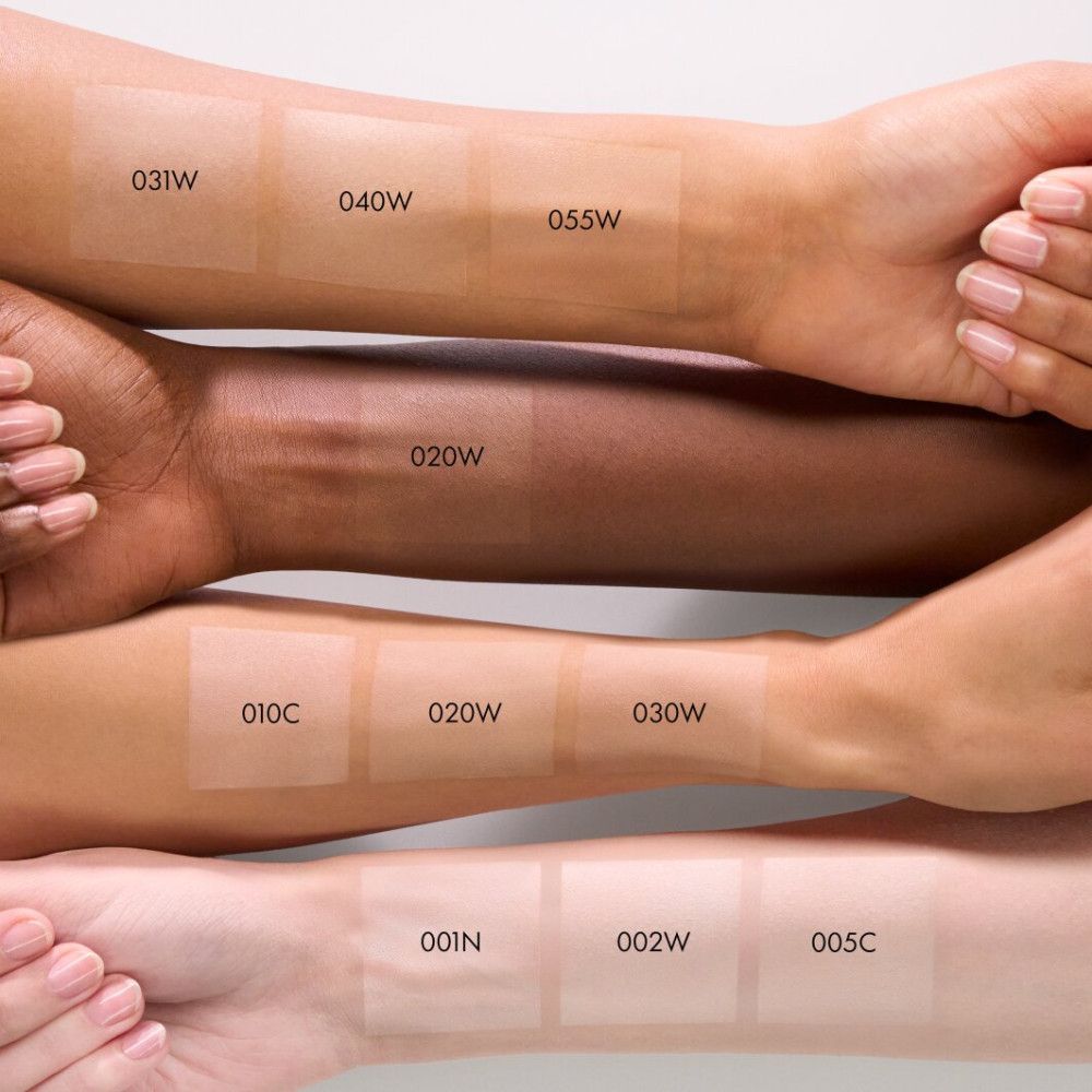 Arme mit verschiedenen Hauttönen, auf denen Puderproben aufgetragen wurden. Auf jedem Arm sind mehrere Farbtöne zu sehen.