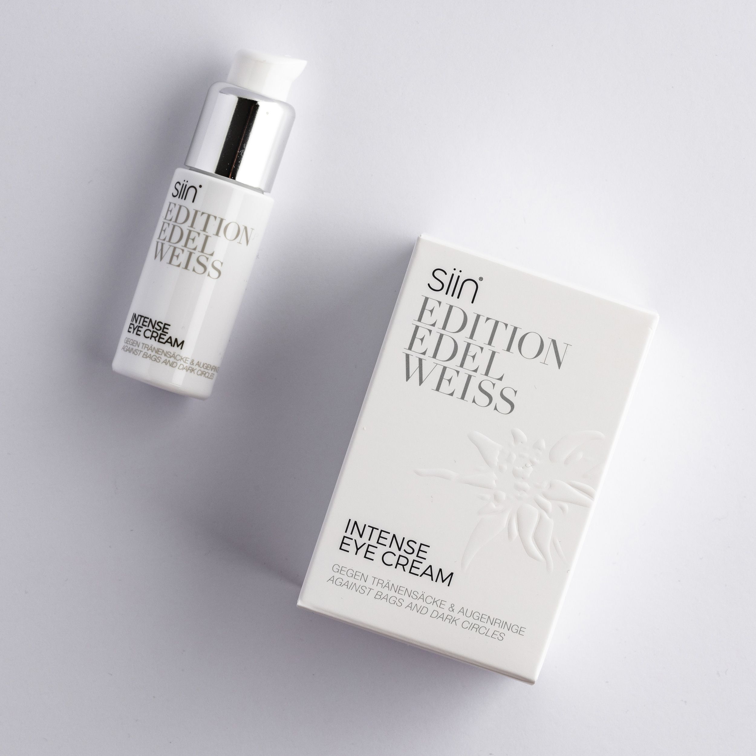 Weiße Flasche mit silbernem Pumpkopf und Produktverpackung. Aufschrift: "siin Edition Edelweiss Intense Eye Cream".