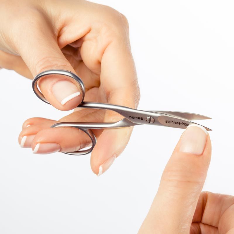 Nagelschere für Linkshänder in Anwendung. Eine Hand hält die Schere, die andere den Nagel. Marke: remos lefty.
