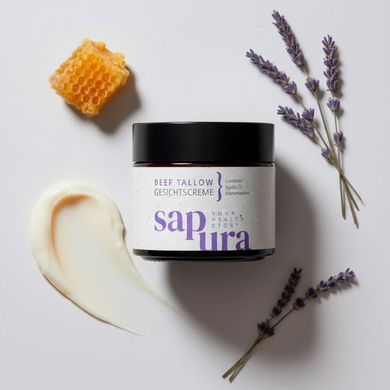 Creme-Tiegel mit schwarzem Deckel, daneben Lavendelblüten und Honigwabe. Aufschrift: Beef Tallow Gesichtscreme, Marke: sapura.