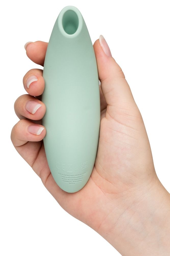 Hellgrünes Wellness-Produkt in einer Hand gehalten. Abgerundete Form. Rückseite mit Text. Keine weiteren Details.