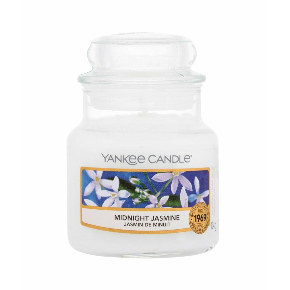 Kleine Duftkerze im Glas mit Deckel. Aufkleber mit Blumenmotiv und Schriftzug "Midnight Jasmine". Marke: Yankee Candle. Goldener Aufkleber.