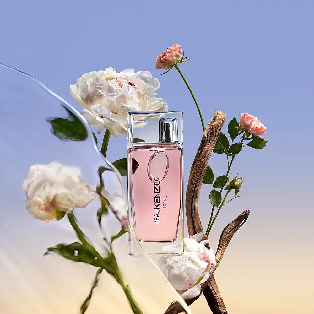L'Eau Kenzo Pour Femme Florale Eau de Toilette inmitten von Blumen und Treibholz.