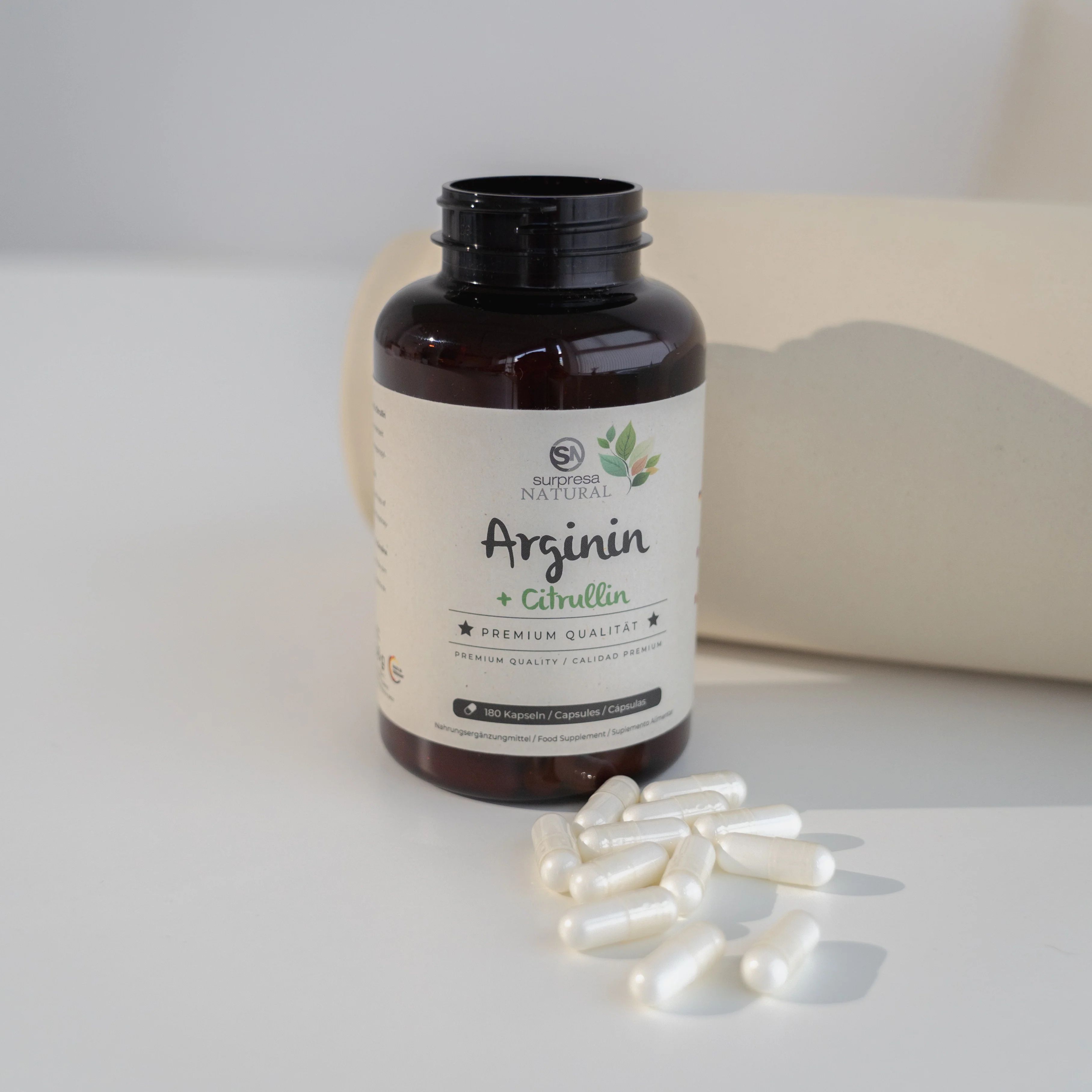 Braune Flasche mit Kapseln und Aufschrift: Surpresa Natural, Arginin + Citrullin, Premium Qualität. Kapseln liegen daneben.