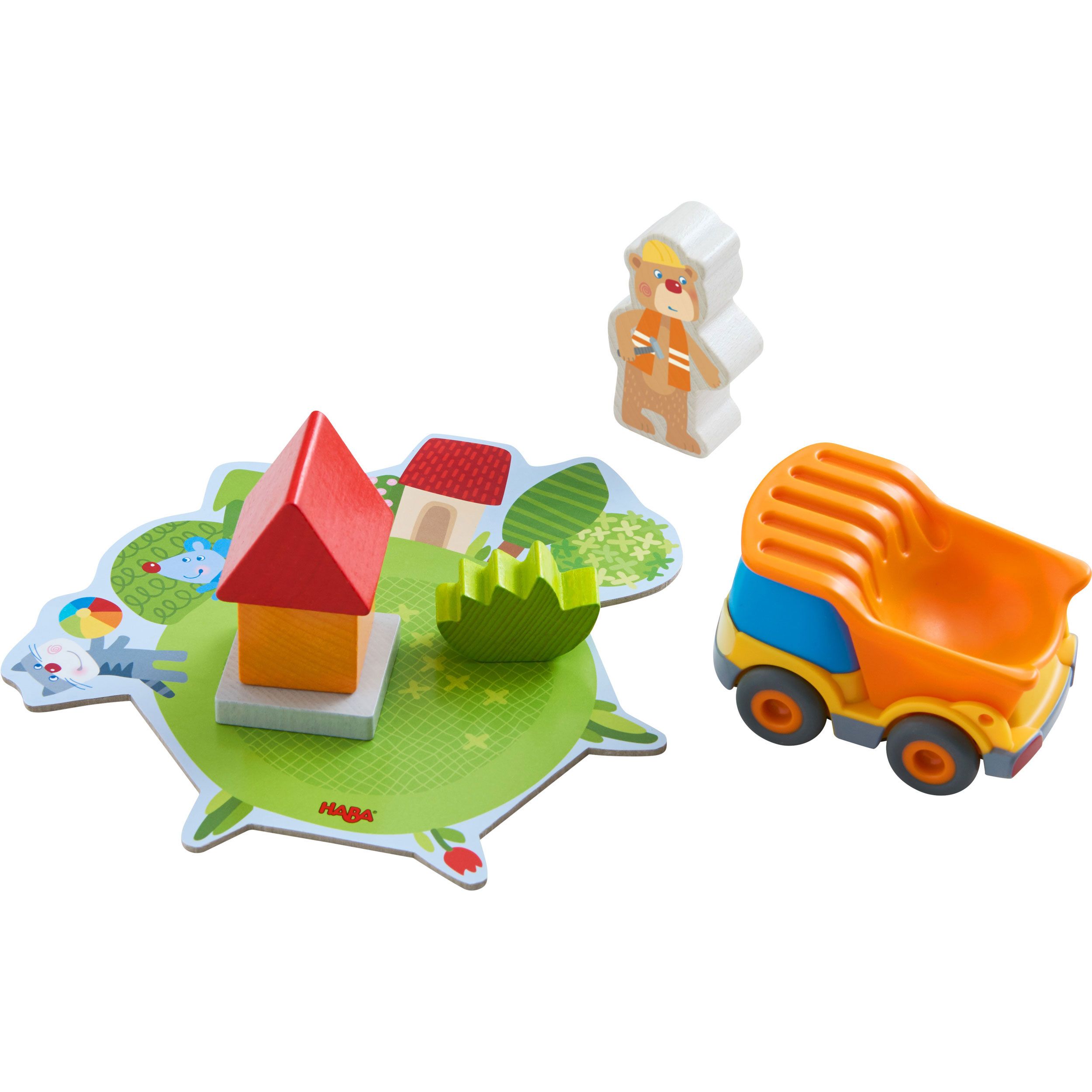 Baustellenspiel mit Spielfiguren, einem LKW, einem Haus und Holzbausteinen. Auf weißem Hintergrund. Verschiedene Farben und Formen.