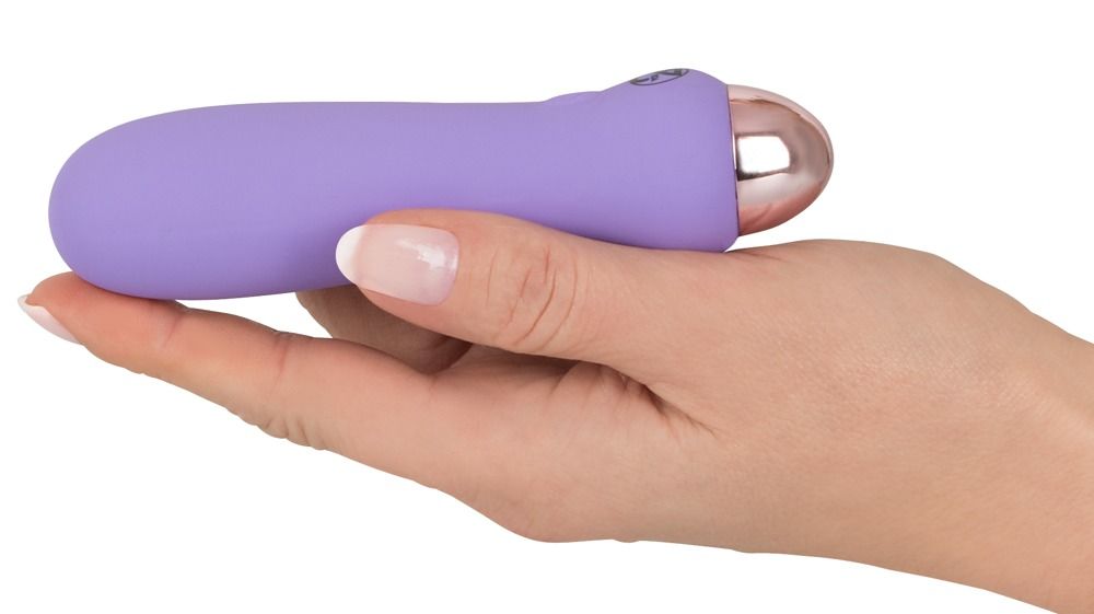Hand hält einen lila Mini-Vibrator mit Soft-Kontur und silberner Spitze.