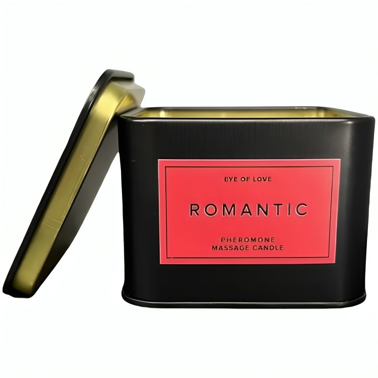Schwarze, rechteckige Dose mit rotem Etikett. Aufschrift: EYE OF LOVE, ROMANTIC, Pheromone Massage Candle. Deckel daneben.