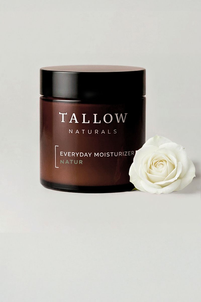 Braune Dose mit schwarzem Deckel. Aufschrift: Tallow Naturals, Everyday Moisturizer Natur. Daneben eine weiße Rose.