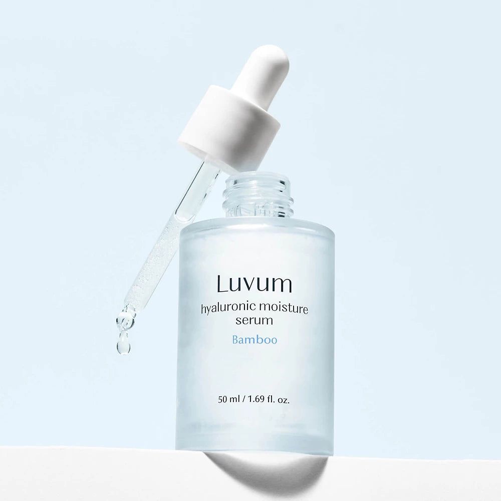 Glasflasche mit Pipette. Aufschrift: Luvum, Hyaluronsäure Feuchtigkeitsserum, Bambus. Tropfen fallen aus der Pipette.