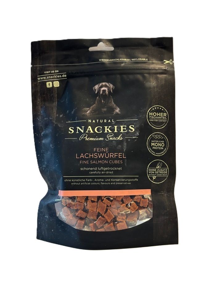 Verpackung mit Lachswürfeln. Aufschrift: Snackies, Feine Lachswürfel, ohne künstliche Farb-, Aroma- und Konservierungsstoffe. Siegel: Hoher Fischanteil, Mono Protein.