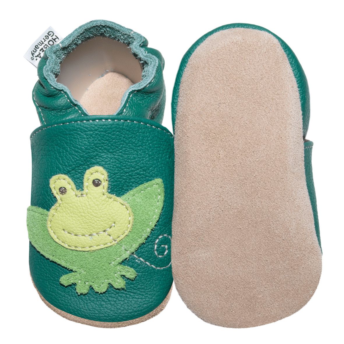 Grüner Kinderschuh mit Froschmotiv. Marke HOBEA-Germany. Aus Leder. Schuh und Sohle nebeneinander, Froschgesicht auf dem Schuh.