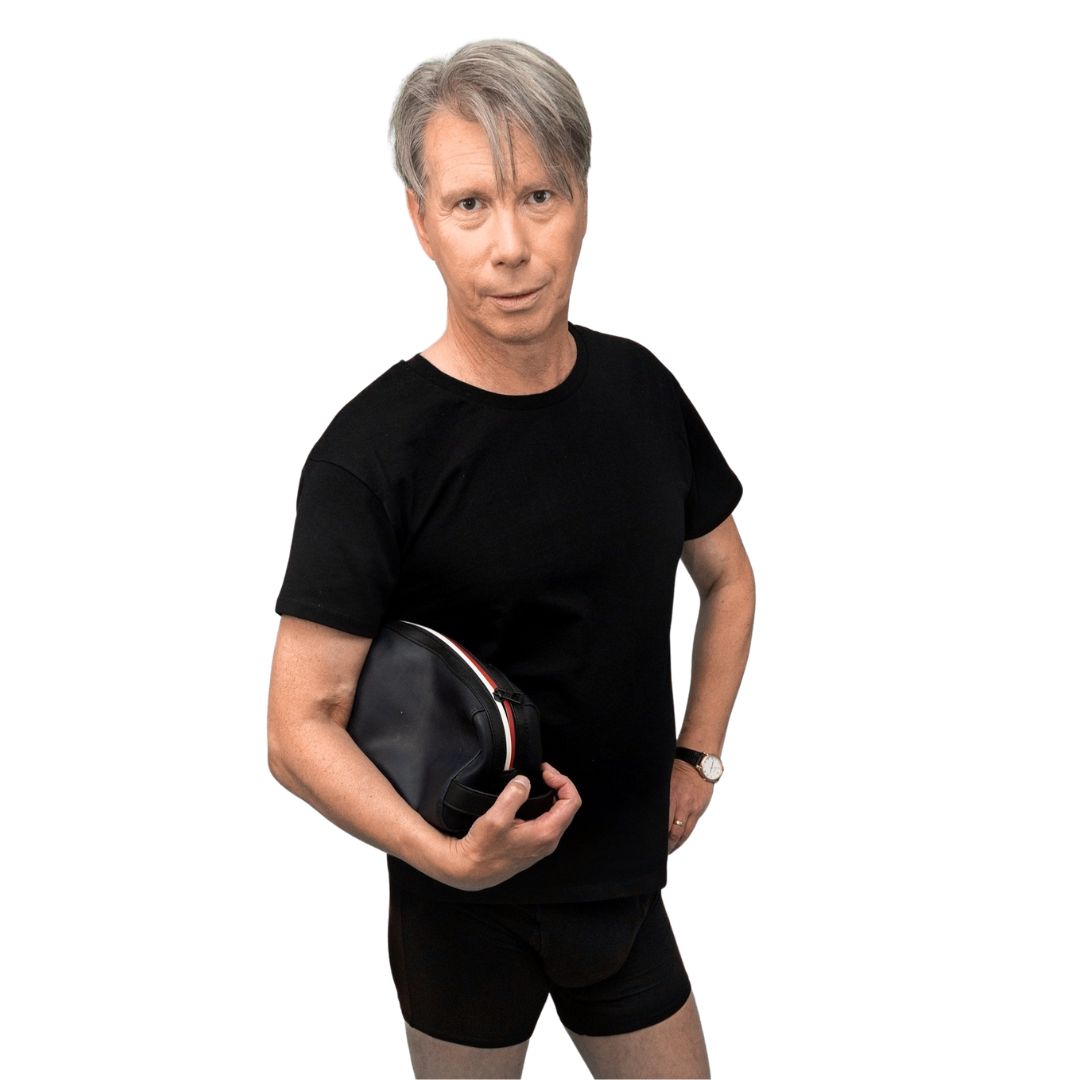 Mann mit schwarzem T-Shirt und Boxershorts, hält eine schwarze Tasche.