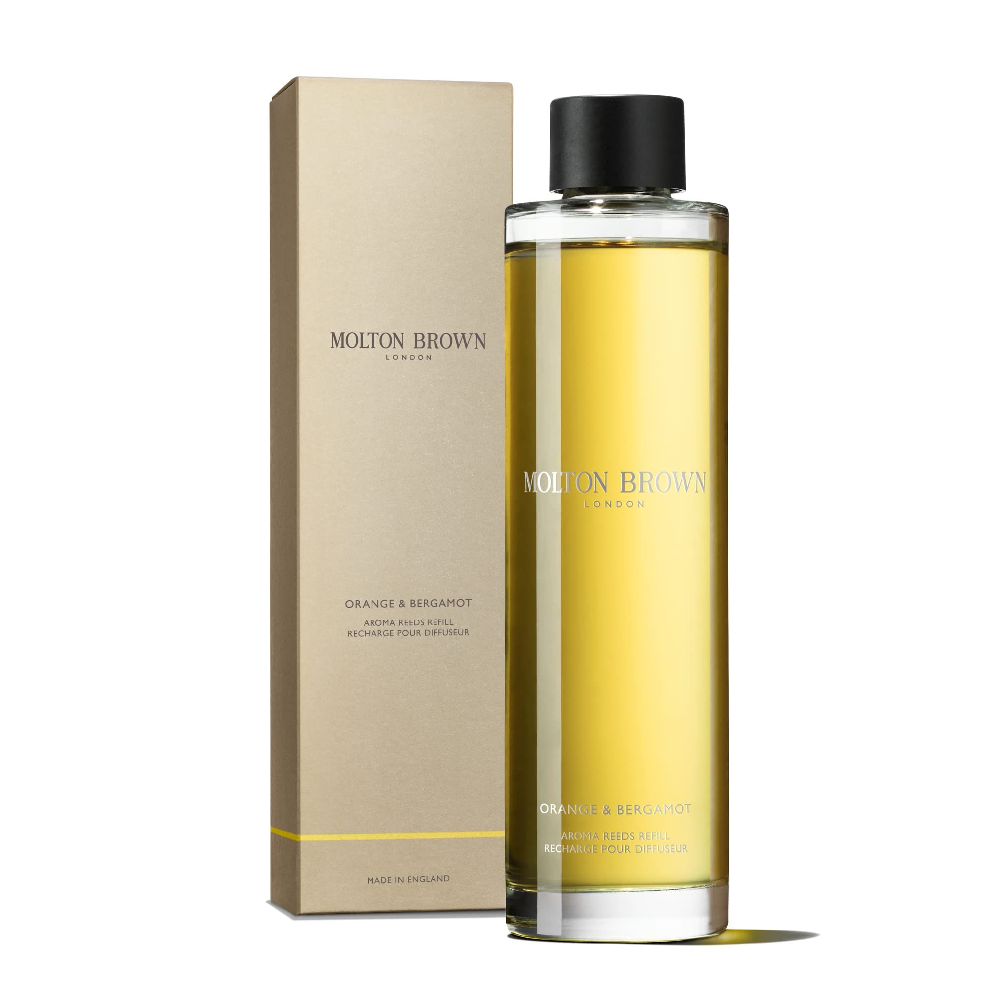 Molton Brown Orange & Bergamotte Aroma Refill in Glasflasche mit schwarzem Verschluss, neben der Verpackung.