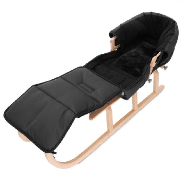 Schwarzer Lammfell Schlittensack auf Holzschlitten. Liegeposition. Schwarzes Innenfutter.