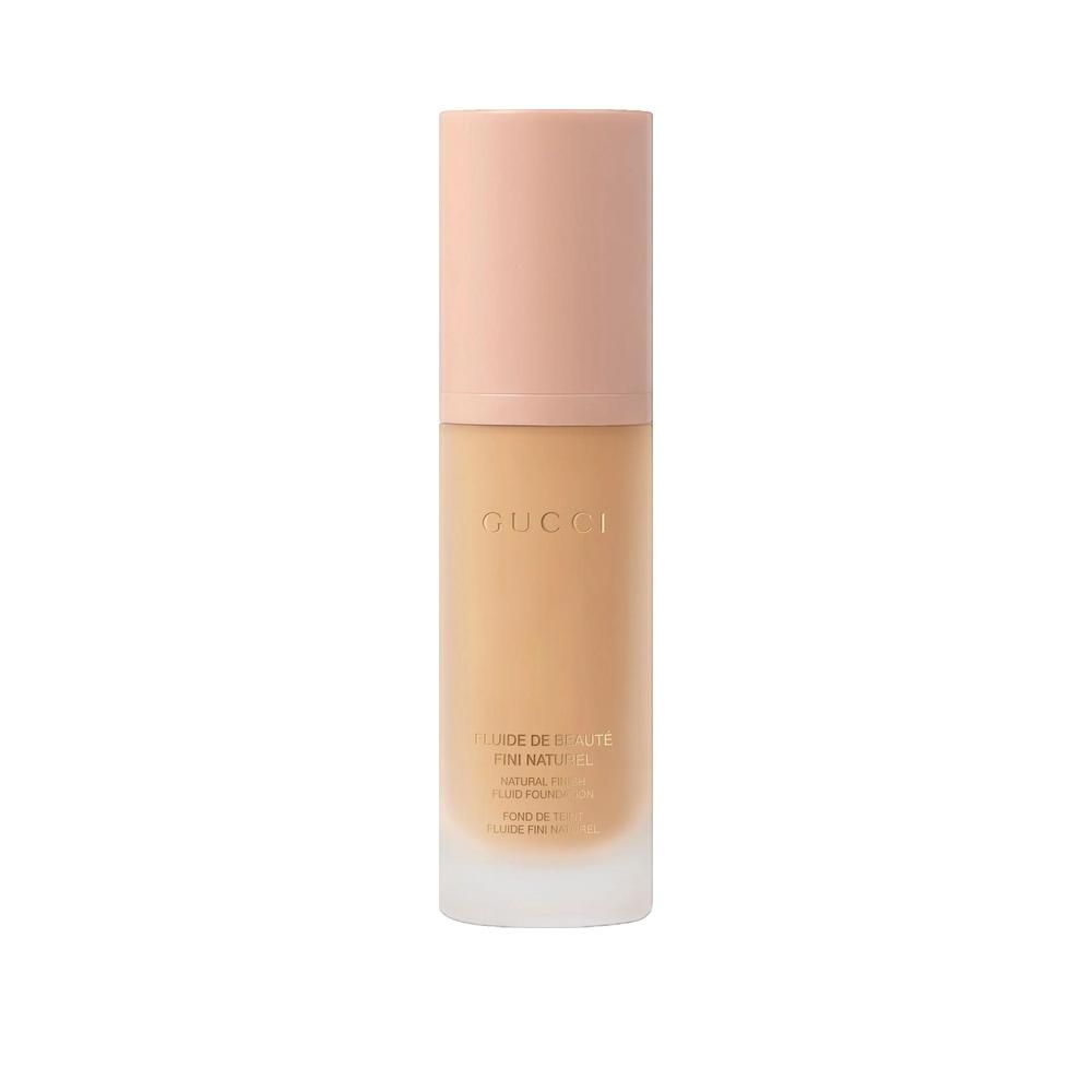 Beige Flasche mit rosafarbenem Deckel. Aufschrift Gucci. Produktname und weitere Informationen auf der Flasche.