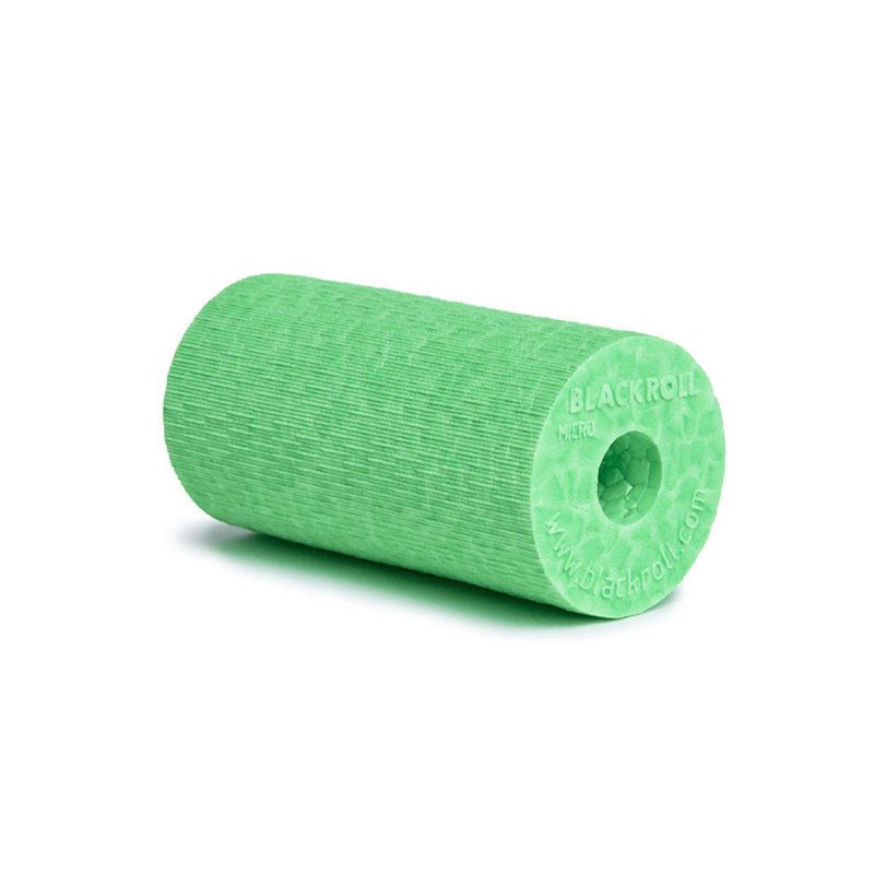 Zylindrische, grüne Faszienrolle. Mit geriffelter Oberfläche und zentraler Öffnung. Aufschrift: BLACKROLL.