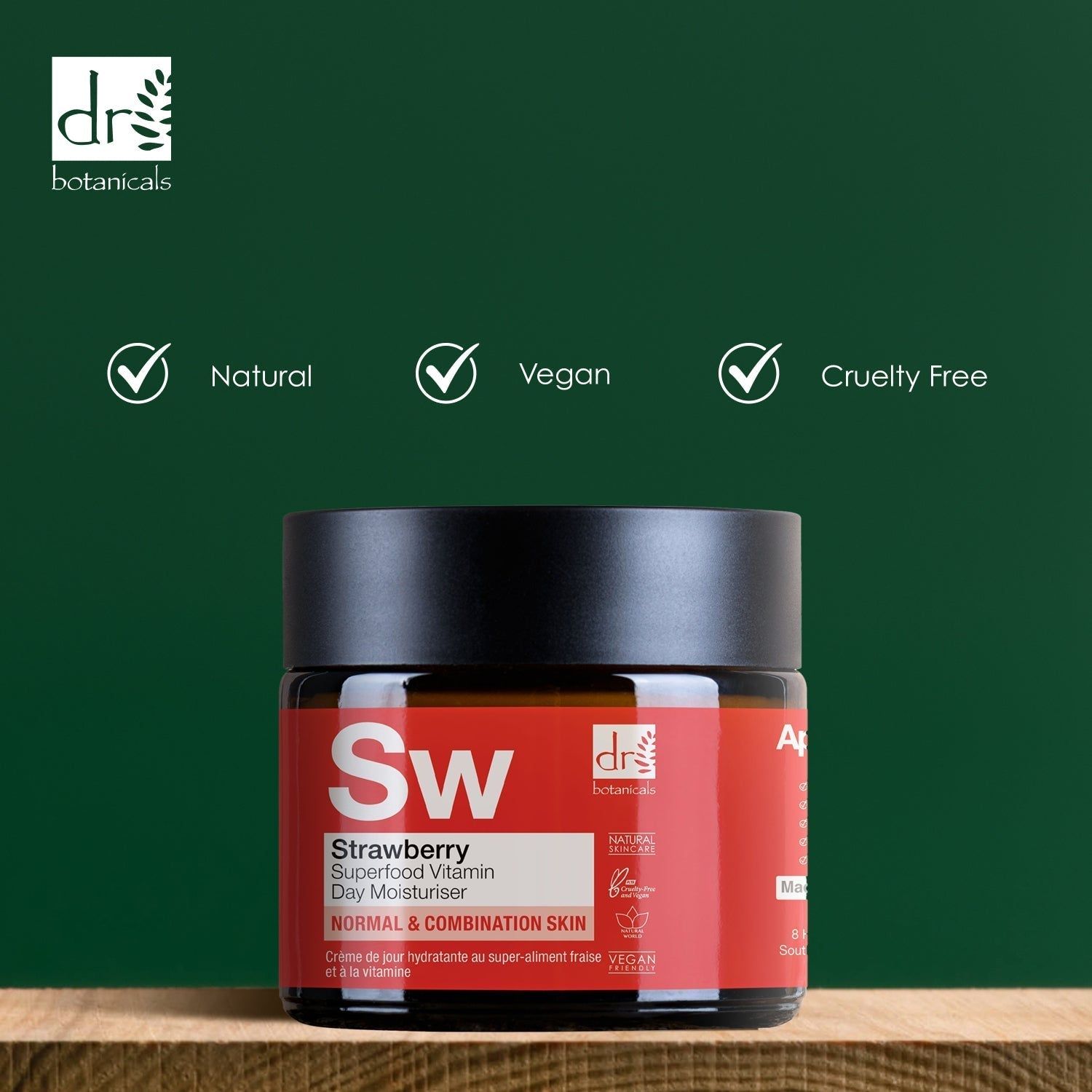 Creme-Dose mit schwarzem Deckel auf Holzblock. Aufschrift: Strawberry Superfood Vitamin C Day Moisturiser. Marke: Dr Botanicals. Vegan, Natural, Cruelty Free.